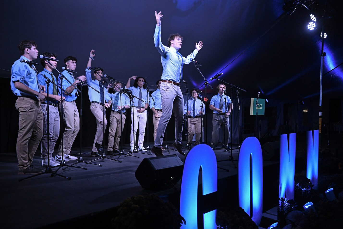 A male performer leaps during an a cappela performance at Fall Weekend 2024