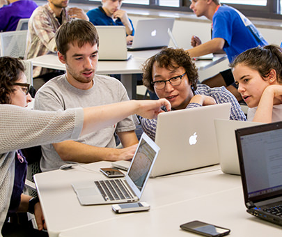 Computer science students engaging with a professor during class.