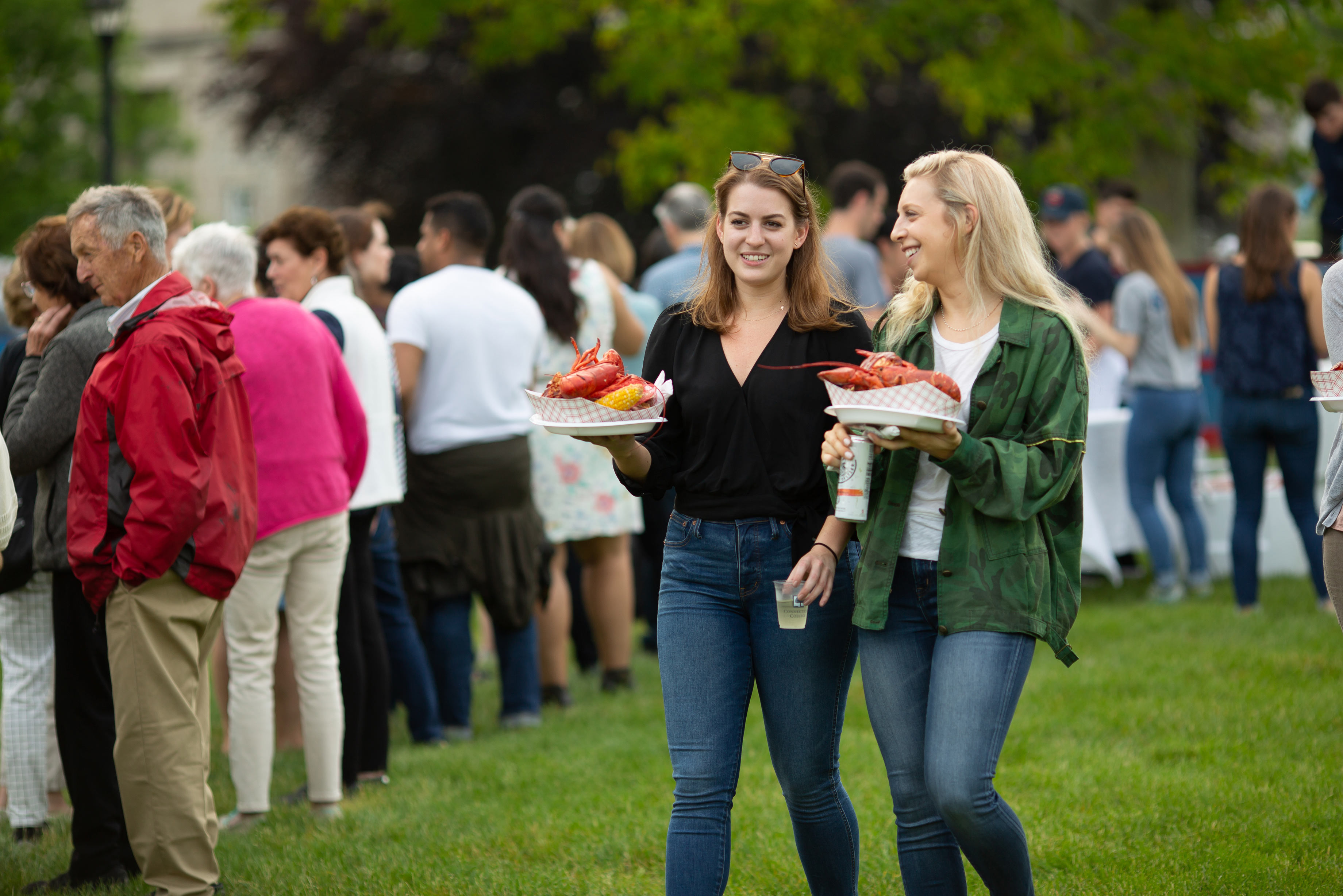 Alums carrying plates of lobster at Reunion 2018