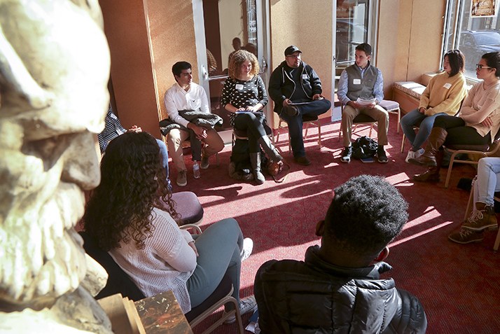 Students talk in a small group as one of the Garde's statues looks on