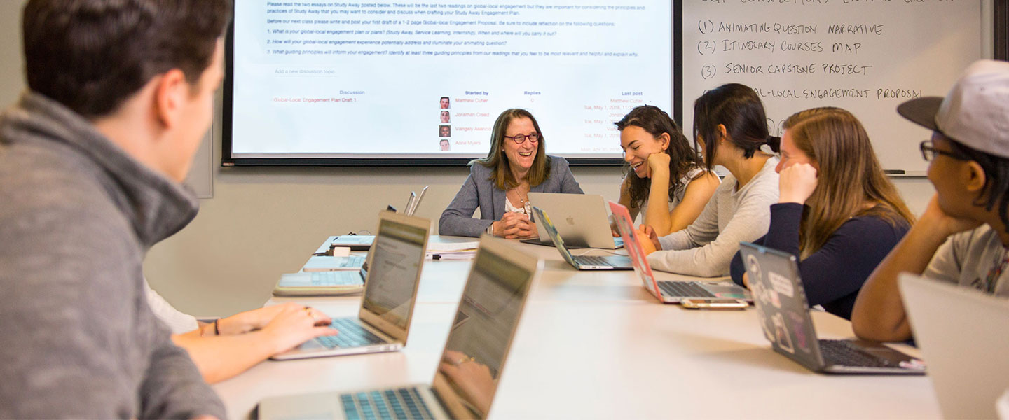 Students sitting around a table with laptops