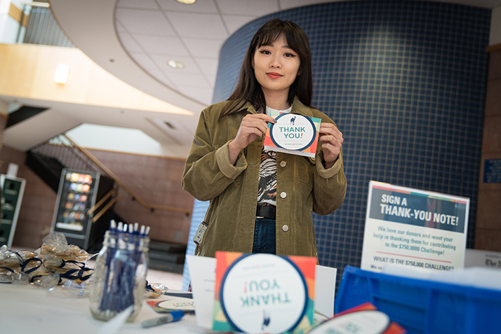 A student holds a Thank You card