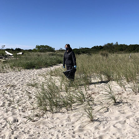 Nicole Wright ’24 picks up garbage at Ocean Beach Park in New London. Photo by Winona Hunter ’24.