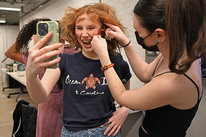 an actor laughs as her microphone is affixed