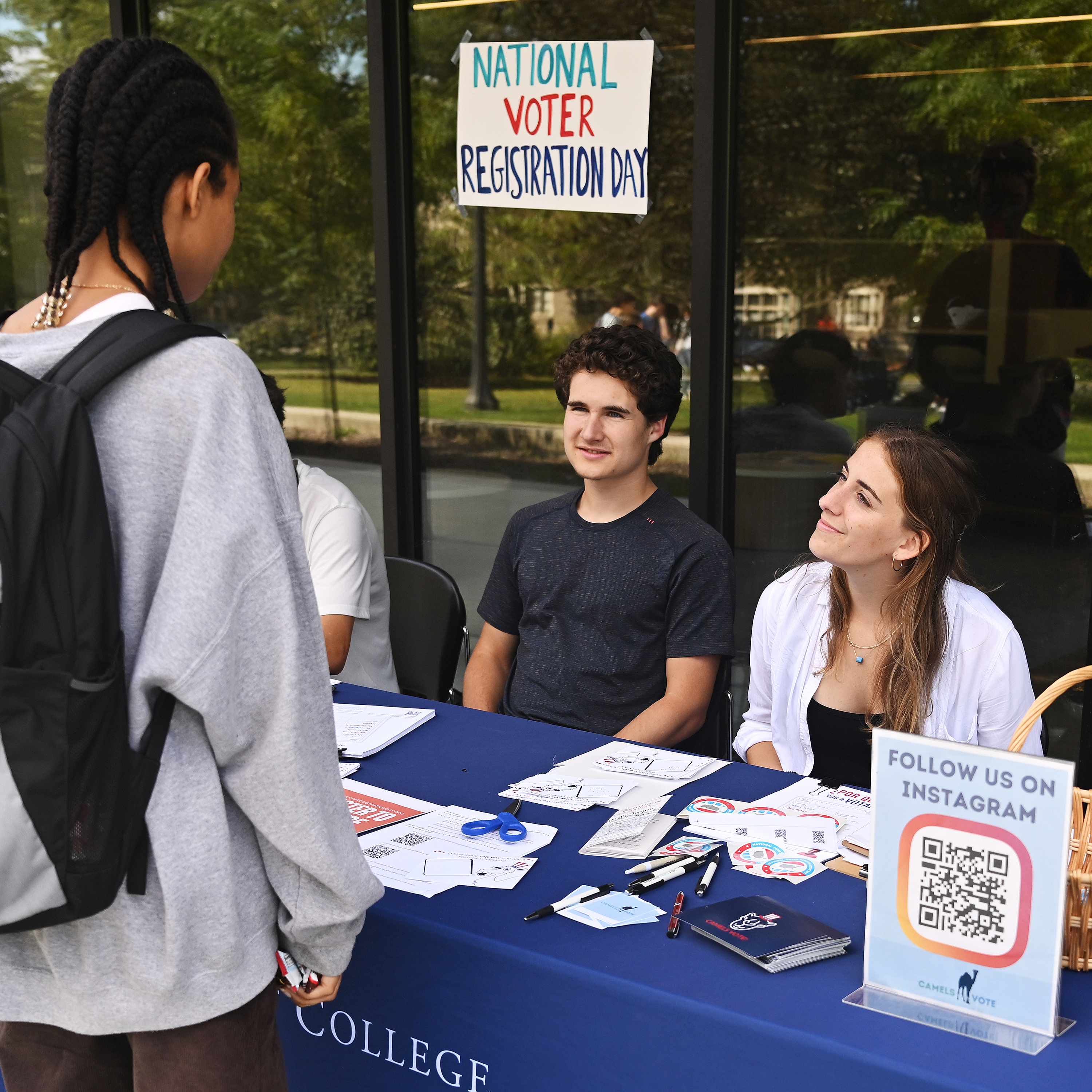 Miranda Van Mooy ’24, right, speaks to a student during a voter registration drive in front of Shain Library.