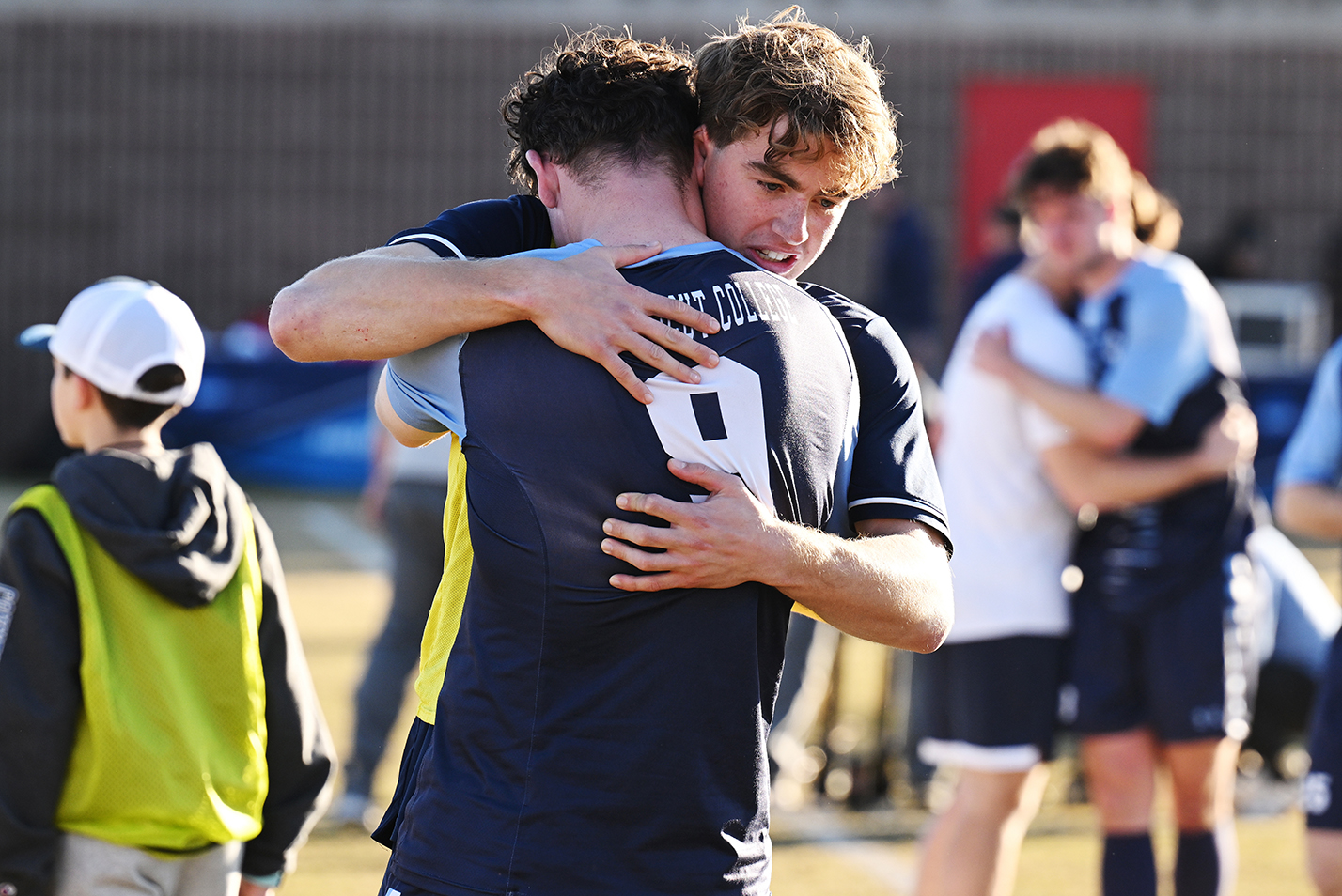 Two soccer players embrace after a loss.