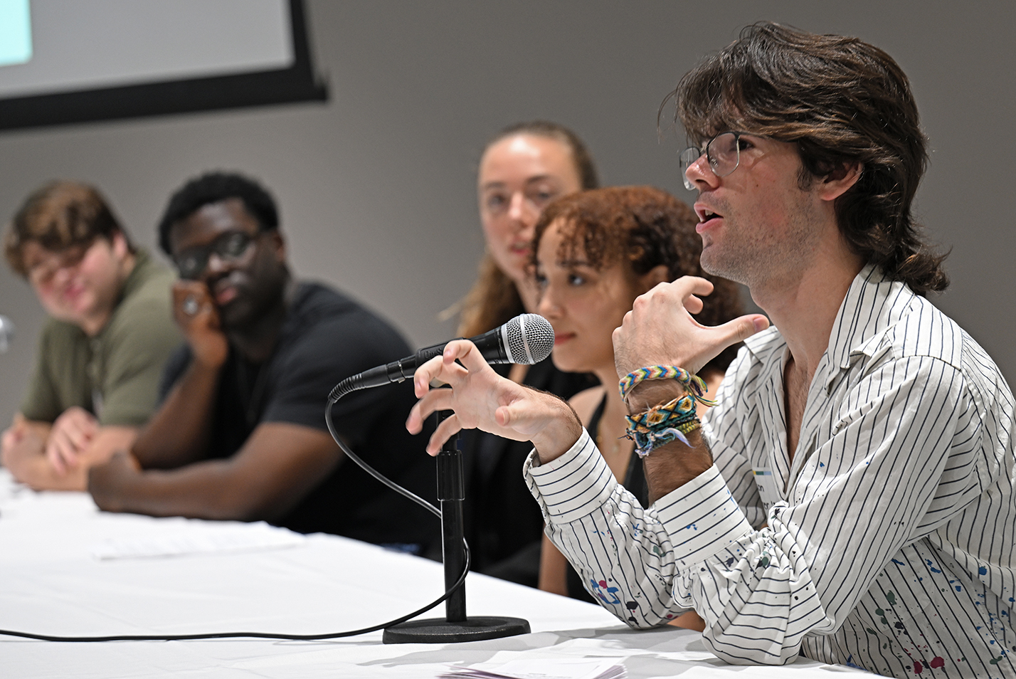 One student in a group sitting at a table speaks.