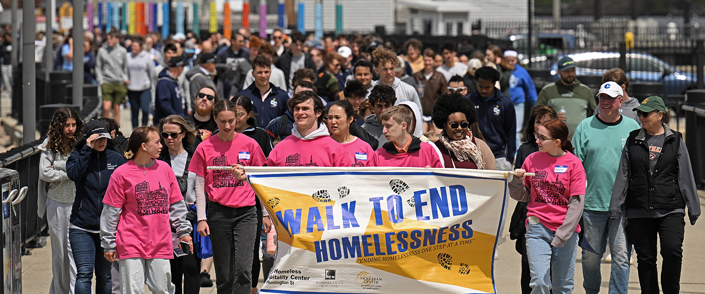 Hundreds of people walk down a New London street as part of the Walk to End Homelessness.